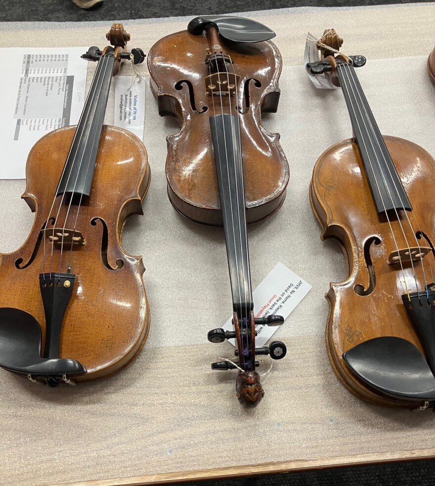 Three of the 67 violins, cello and viola that are in the "Violins of Hope" exhibit through April in the Quad Cities.