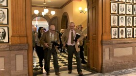  Lawmakers leave the Kansas House chamber after voting to override the governor's veto of a redistricting plan.