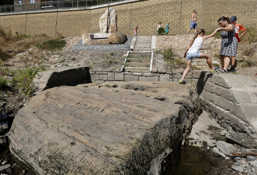 People visit a famous "hunger stone" exposed by the low level of water in the Elbe river in Decin, Czech Republic, on Thursday.