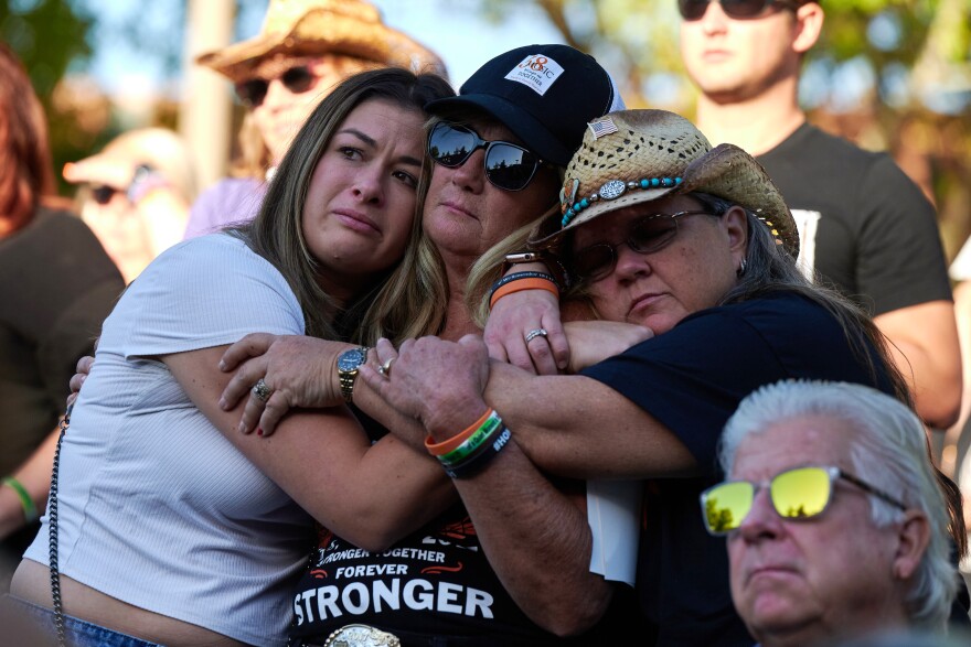 Lauren Reh, Alicia Mierke and Sue Ann Cornwell embrace during the Sunrise Remembrance ceremony at Clark County Government Center Amphitheater in Las Vegas on Oct. 1, 2022.