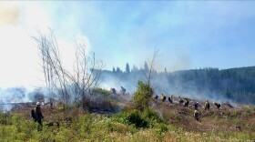 Wildland firefighter trainees work along a smoky ridge 