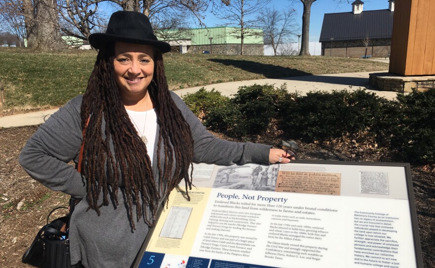 Professor Michelle Wright stands next to one of the campus's historic markers. Credit: John Lee