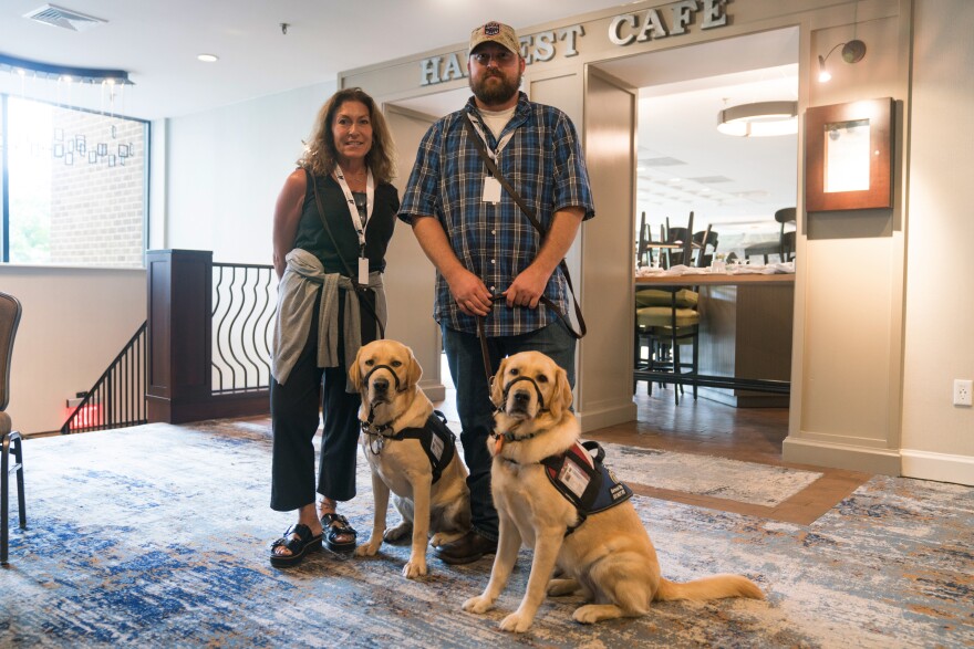 Gina Esoldi stands with her service dog Ricky along with Kyle Santiago with his dog Kassi. Both work with Next Step Service Dogs.