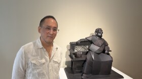 Artist Warren King stands next to his cardboard sculpture titled "The Emperor Takes Five."