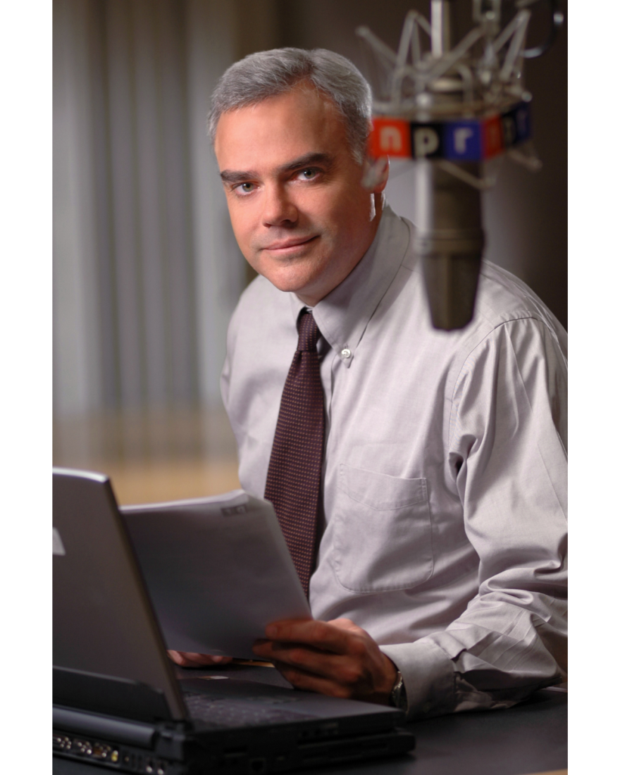 Scott Horsely Sitting In front of a computer holding papers