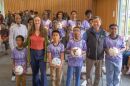 A group of adults and children in soccer jerseys pose for a picture.