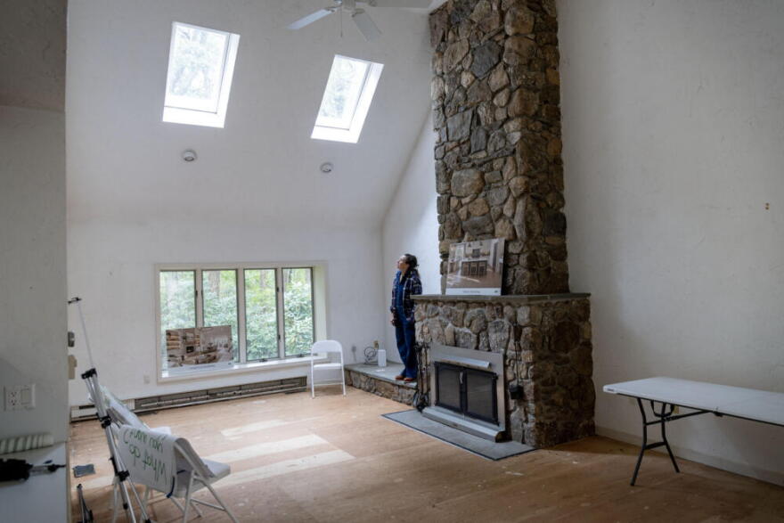 Susie Shaw stands by what will be the "kindness hearth" at the Green House Retreat in Falmouth, Mass. (Robin Lubbock/WBUR)