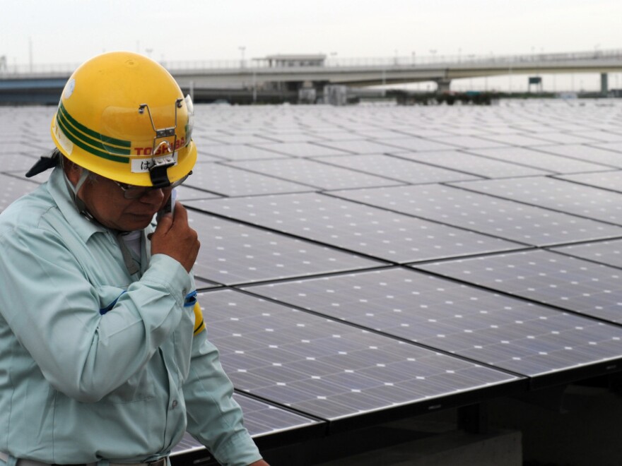 <p>A worker stands next to an array of Sharp solar cell modules at a power plant south of Tokyo in August. Sharp was one of 1,400 solar panel manufacturers in attendance at the Solar Power International conference, where industry optimism was high.</p>