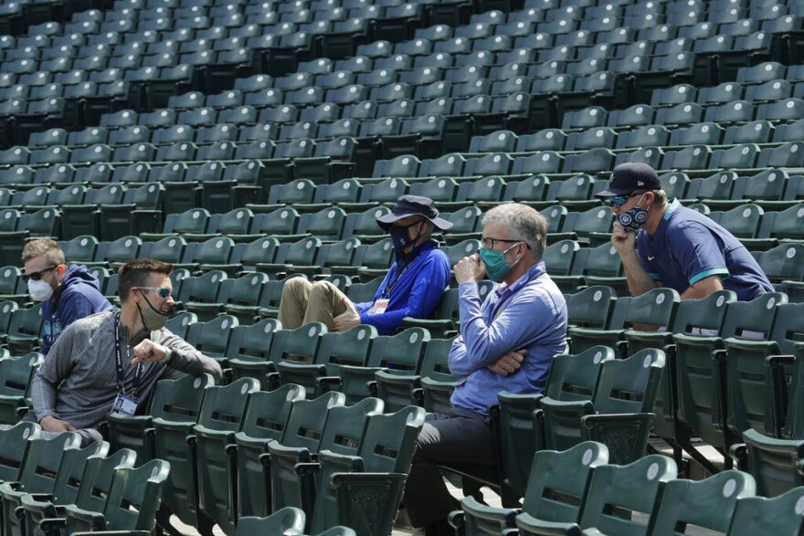  Seattle Mariners general manager Jerry Dipoto, second from left, manager Scott Servais, right, and former team president and CEO Kevin Mather, second from right, watch from the stands during baseball practice in Seattle, in this July 8, 2020, photo. 