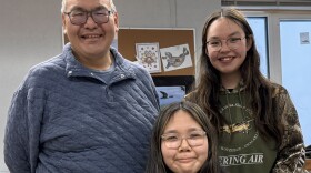 Three people smile and look ahead.