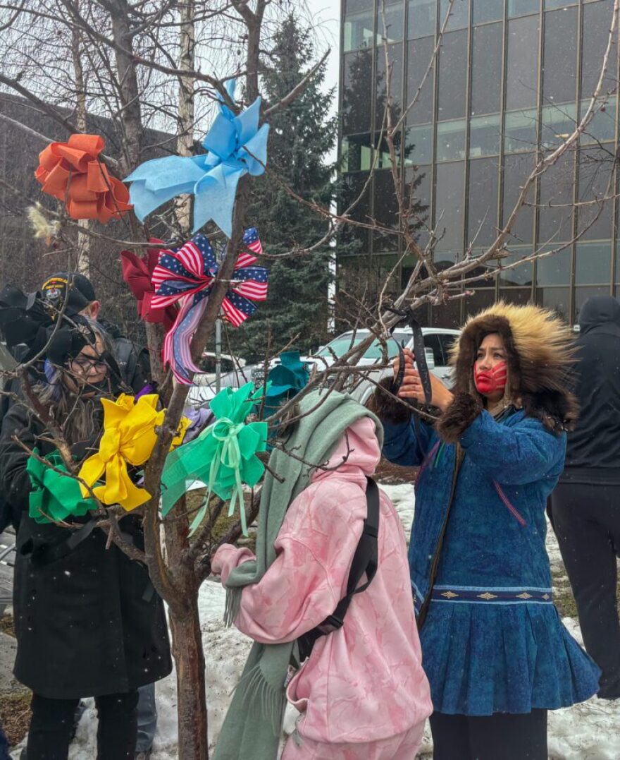 Missing and Murdered Indigenous People advocate Antonia Commack, right, hangs a ribbon at the annual Ceremony of Remembrance in Anchorage.