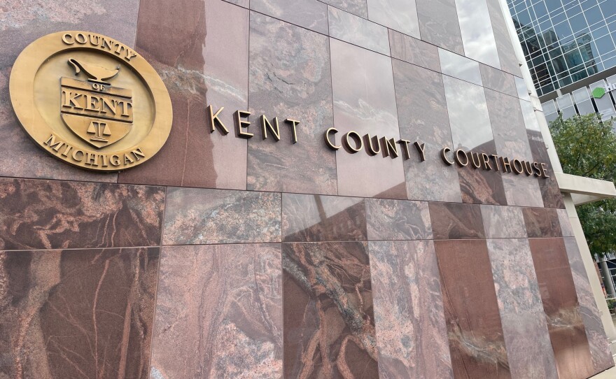 The red marble facade of the Kent County Courthouse building. In the middle of the frame is the seal of Kent County, followed by the words "Kent County Courthouse."