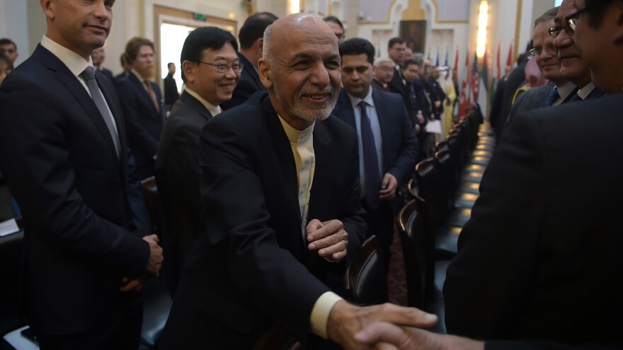 Afghan President Ashraf Ghani shakes hands with a foreign delegate at the Kabul Process conference in the country's capital Wednesday. During the conference, Ghani called on the Taliban to participate in peace talks with the Afghan government.