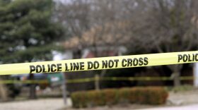 Police tape hangs across the street in front a house in Park City, Kansas. 