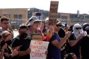 People protest outside of an immigration facility guarded by federal agents Friday, Sept. 12, 2025, in in Broadview near Chicago.