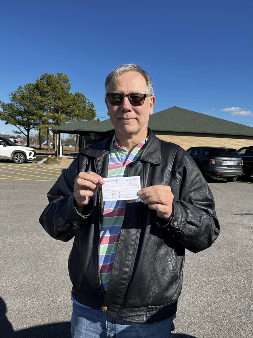 David Cornsilk holds up a receipt after paying to register to run for Principal Chief of Cherokee Nation.