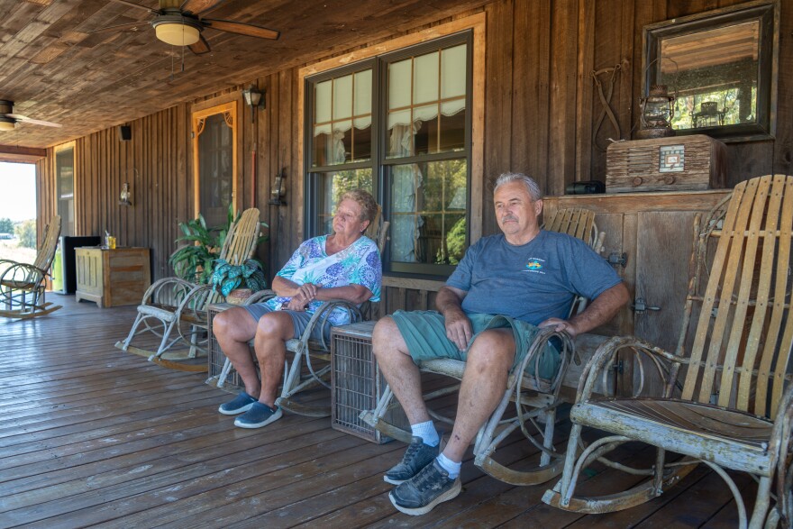 Cynthia (left) and Mike Trentham (right) look out from their front porch at a fractionation plant operated by the NGL Supply Co., which moved in across the street from their family farm in Bulls Gap, Tenn. last year. They say the flame burns day and night, casting harsh light through their windows as they sleep and disturbing their cattle.