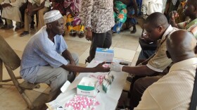 Healthworkers test a village chief for lymphatic filariasis, also known as elephantiasis, in the Ivory Coast.