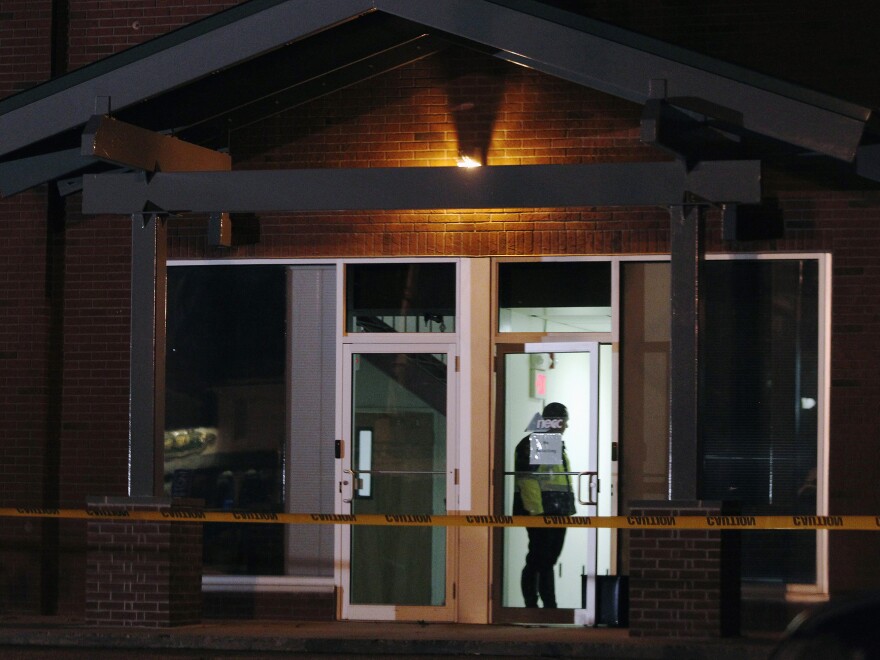 A Framingham police officer  keeps watch as federal agents search the New England Compounding Center company in Framingham, Mass., on October 16.