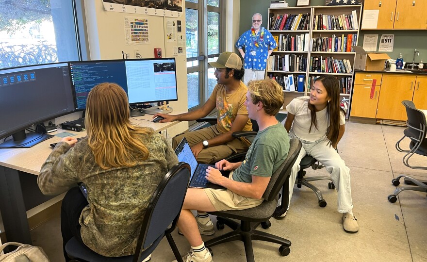 Students Kate Stingle, Akshay Sathish (foreground), Drew Stannard-Stockton (front-center) and Kayla Wong (right) work at the CubeSat Laboratory.