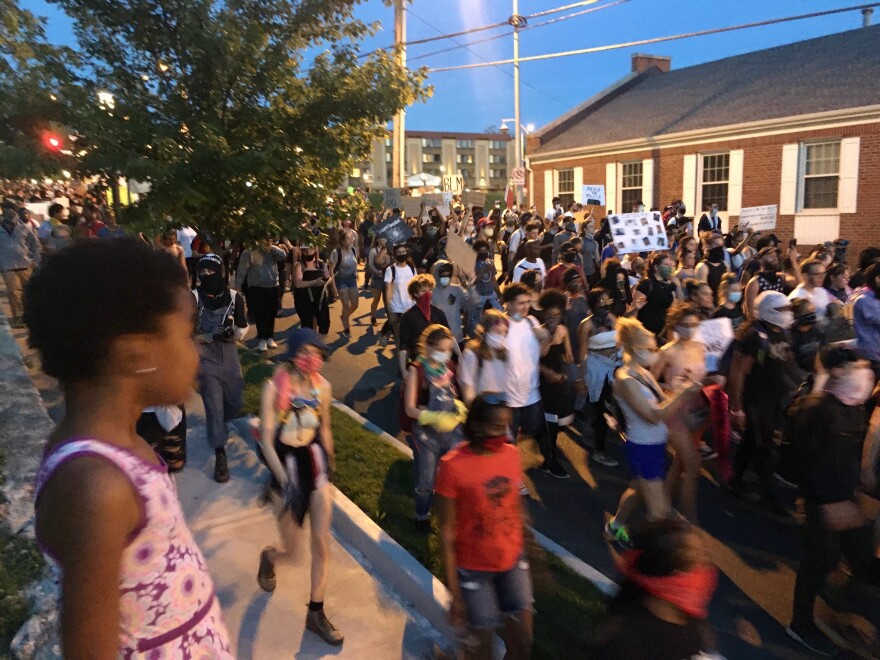 A young girl watches as hundreds march near the Plaza on Tuesday night.