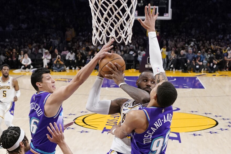 Los Angeles Lakers forward LeBron James, center, tries to pass the ball as Utah Jazz forward Simone Fontecchio, left, and forward Juan Toscano-Anderson defends during the second half of an NBA basketball game Sunday, April 9, 2023, in Los Angeles. The Utah Jazz will begin making their game broadcasts available over-the-air starting this coming season, becoming the latest franchise to pivot to a new option for fans and potentially reaching more viewers than ever before. The Jazz unveiled their plan Tuesday, June 20, 2023, with owner Ryan Smith announcing the launch of his new production company called SEG Media.