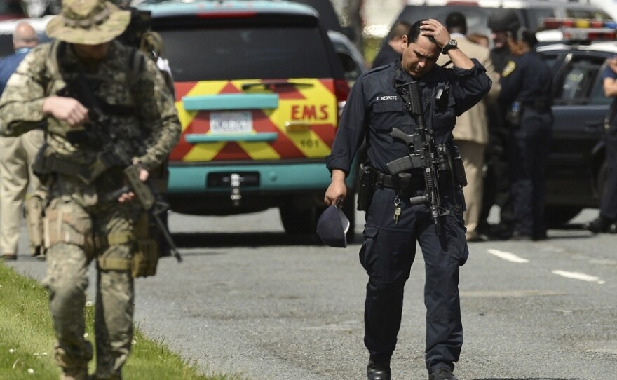 An Oakland police officer walks outside Oikos University, the scene of Monday's shooting that left at least seven people dead.
