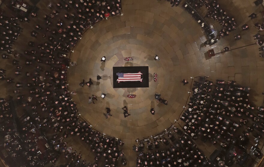 The Bush family walks past the casket of former President George H.W. Bush as he lies in state in the U.S. Capitol Rotunda Monday, Dec. 3, 2018, in Washington. 