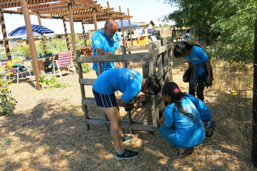 Kids in the program construct a compost bin under the supervision of Chris Lines, whose wife, Denise, founded Growing Colorado Kids.