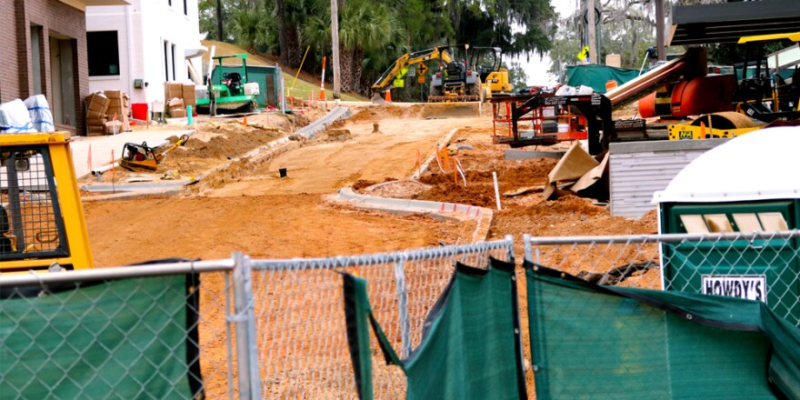 Construction site and equipment behind a gate.