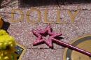 A wand with a star is placed over Dolly Parton's star on the Hollywood Walk of Fame Tuesday, Aug. 25, 2026, in Los Angeles. (Chris Pizzello/AP)