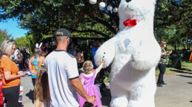 A polar bear greets children around the zoo.