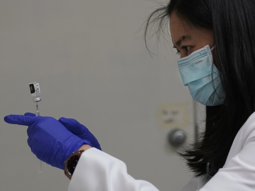 Pharmacist Marie Antonette Tambot prepares Pfizer-BioNTech COVID-19 vaccinations for healthcare workers at Seton Medical Center, Thursday, Dec. 24, 2020, in Daly City, Calif. (AP Photo/Jeff Chiu)