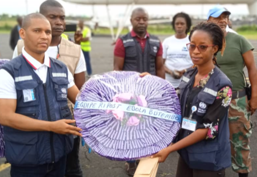 Members of the Ebola response team led by Dr. Mouzoko display a funeral wreath. A service was held in Congo in his memory on Saturday.