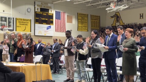 People holding their hand up while giving Oath of Allegiance, the final step to giving citizenship at a ceremony in Kettering on February 12.
