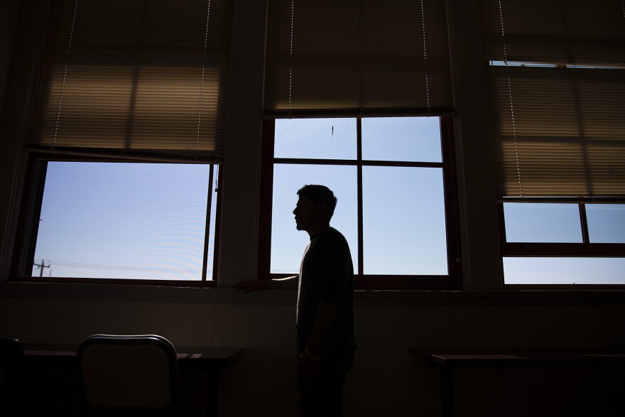 Manuel stands next to a window in his English class. 