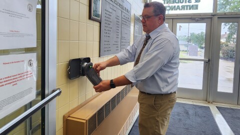 Wyoming Area Superintendent Jon Pollard demonstrates how to use a Yondr pouch.