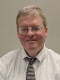 A man in a button-down shirt and tie.