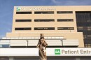 a statue of a woman in a robe and a crown stands in front of a building labeled "patient entrance" 