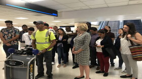 Eulen America employee Esteban Barrios is joined by other workers and Miami-Dade County Commissioner Eileen Higgins at Miami International Airport. April 29, 2019.