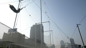 A student of the Trapeze School of New York sails through the air on Oct. 3, 2002, in downtown Manhattan in New York City. (Doug Kanter/AFP/Getty Images)