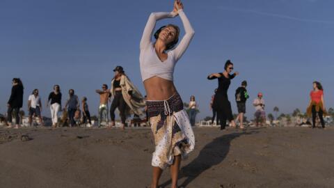 With music playing through wireless headphones, Chase Beckerman, a 37-year-old mother of two children, and other participants dance on the beach. (Jae C. Hong/AP)