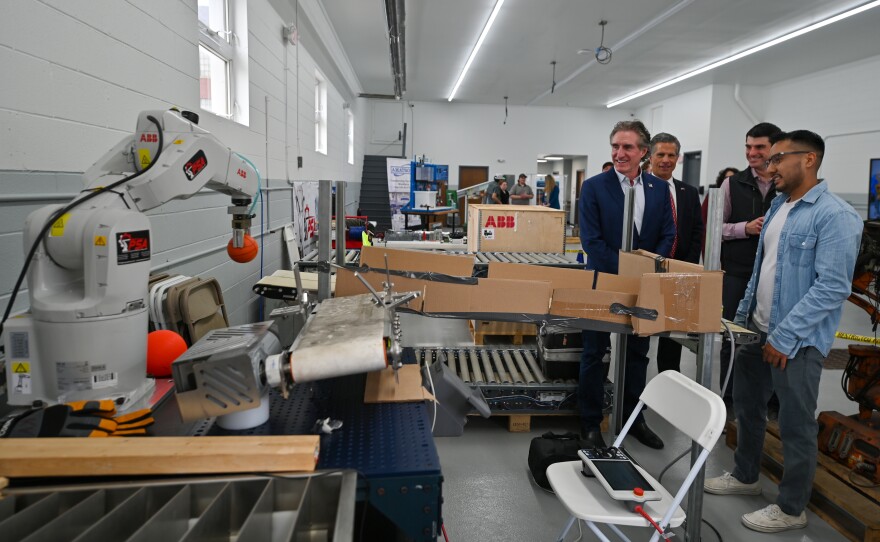 U.S. Secretary of the Interior and chair of the National Energy Dominance council Doug Burgum, left, watches a robot programmed by students move a ball at Lackawanna College. He's joined by Congressmen Dan Meuser and Rob Bresnahan.