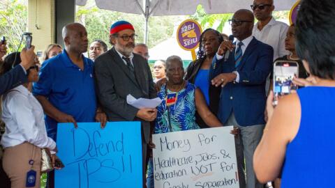 Miami's Haitian community holds signs advocating for TPS and against family separation during the 16th anniversary of Haiti’s 2010 earthquake. (Amelia Orjuela Da Silva for The Miami Times)