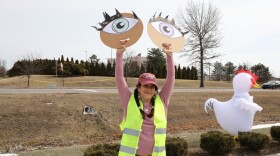 Westside Indy Indivisible Resistance Movement leader Amy Guzman held a pair of cardboard circles with eyes on them. She said the protest is to send a message that ICE officials cannot act anonymously, on Monday, February 16, 2026.