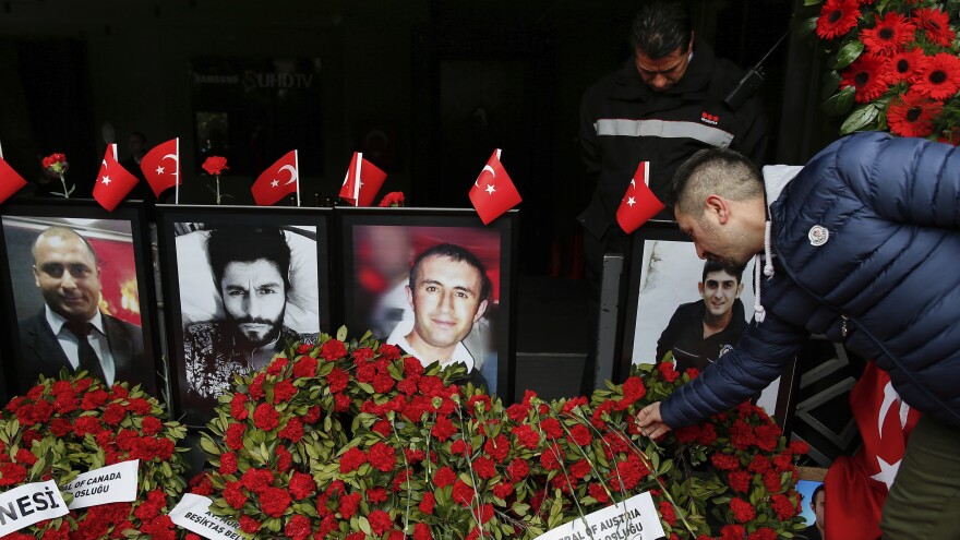 A man leaves a carnation outside Reina nightclub as people have gathered to remember the victims of a deadly New Year's attack a year ago, in Istanbul.