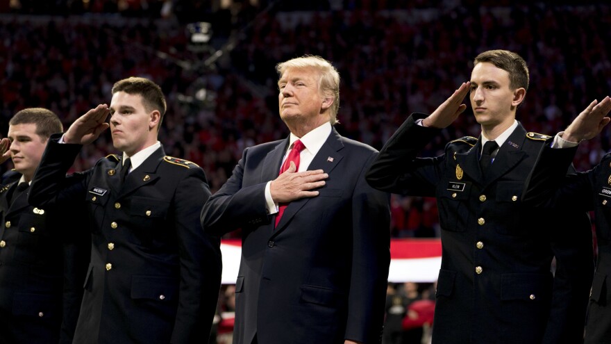 President Trump stands, with his hand over his heart, on the field for the national anthem before the start of the NCAA National Championship football game in January.