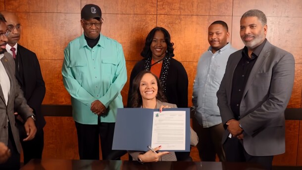 Detroit Mayor Mary Sheffield holds up her first signed executive order as city officials stand behind her.