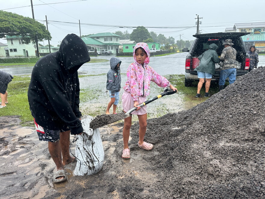Kenzielynn Kekoa, center, of Hilo, Hawaii, helps her family fill sand bags as Hurricane Nolo approaches in Hilo, Hawaii, Friday, Sept. 25, 2026. (AP Photo/Eugene Garcia)