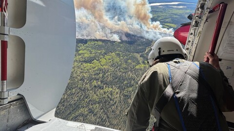 Alaska smokejumper spotter Isaiah Fischer looks down on the Kapsheut Fire as he sizes up the scenario for a fire jump by 12 smokejumpers on June 4, 2026.